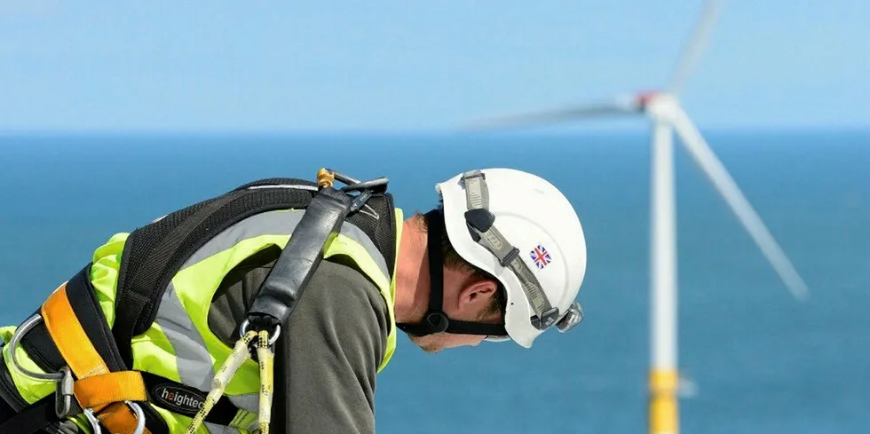 An offshore wind service technician on a turbine.