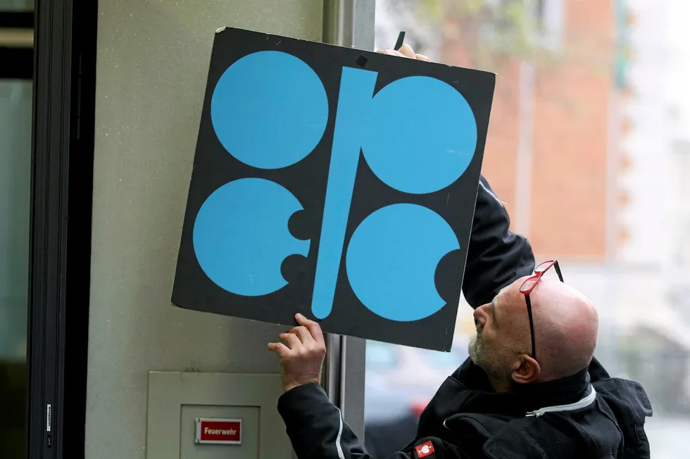 Small change: a worker adjusts an Opec poster at the group's headquarters in Vienna, Austria