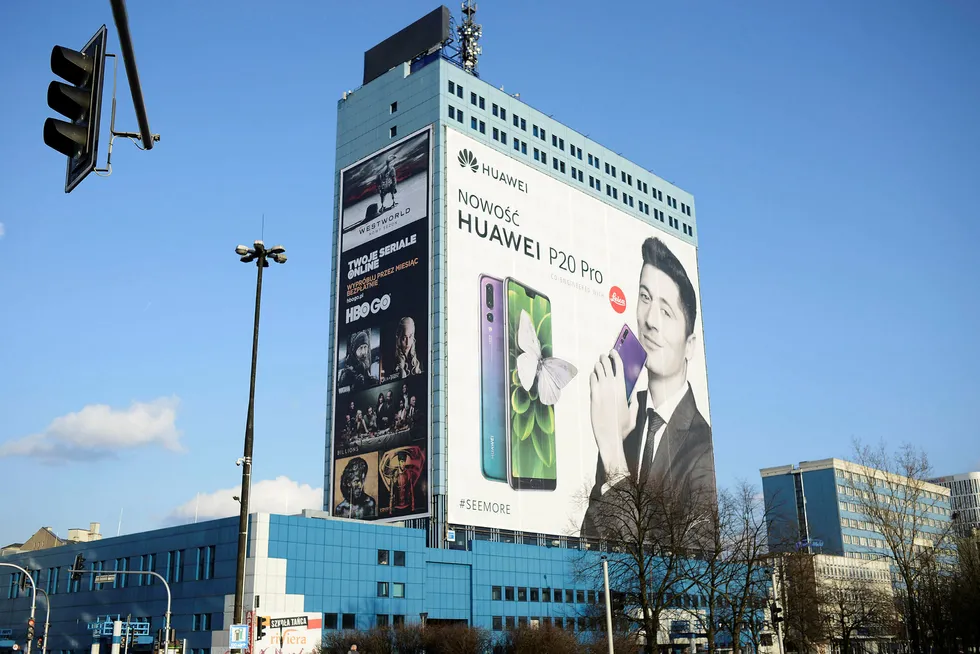 En reklame for Huawei der et bilde av fotballstjernen Robert Lewandowski som holder en smarttelefon dekker en halv bygning i Warszawa.