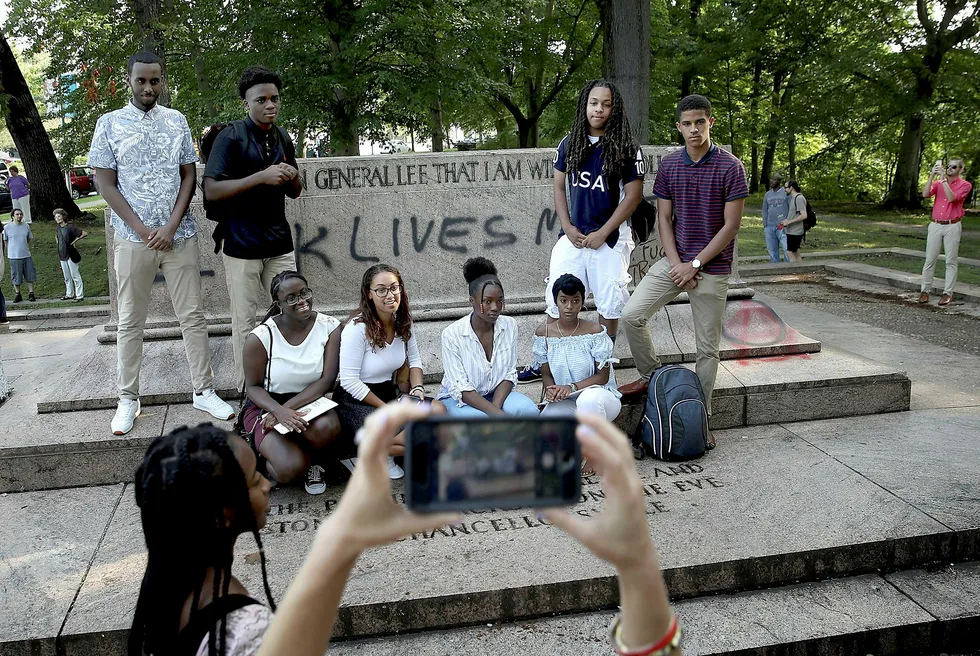 En gruppe studenter poserer foran plassen der statuen som var dedikert til generalene Robert E. Lee og Thomas «Stonewall» Jackson sto. Baltimore by fjernet fire statuer av sørstatsgeneraler over natten. I opptøyene i Charlottesville i etterkant ble en kvinne drept av en høyreekstrem. Foto: Win McNamee/AFP/NTB Scanpix