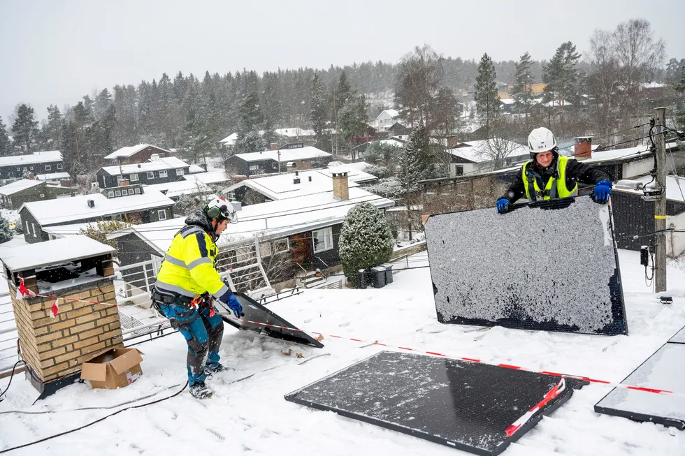Montørene Roy Karlsson og Rune Kiil (til høyre) trosser snøvær for å montere Bjørn Evensens solceller. – Alle som har litt til overs bør vurdere å investere i solceller eller varmepumpe, mener den kommende solcelle-eieren.