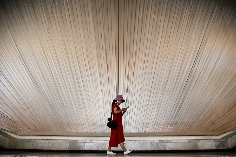 En kvinne ser på mobiltelefonen sin, mens hun vandrer rundt på et utstillingssenter i Shanghai, Kina. Smarttelefonsalget i første kvartal falt med hele 21 prosent sammenlignet med foregående kvartal. Foto: Chandan Khanna/AFP/NTB Scanpix