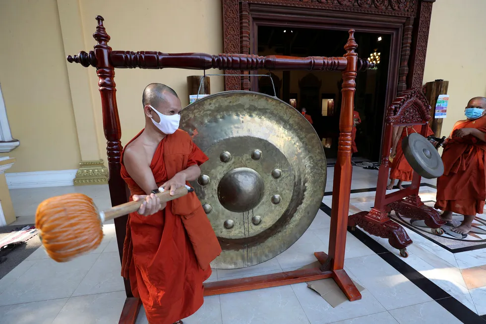 Striking the gong: Buddhist monks at a pagoda in Cambodia