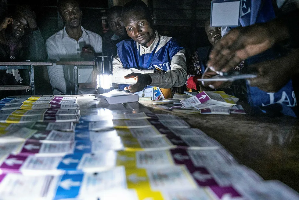 At the count: Independent National Electoral Commission agents count votes during an electricity cut while watched by observers in DR Congo