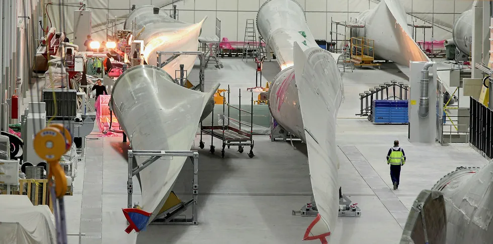 Workers prepare rotor blades for wind turbines at the Enercon wind turbine factory in Aurich, Germany.