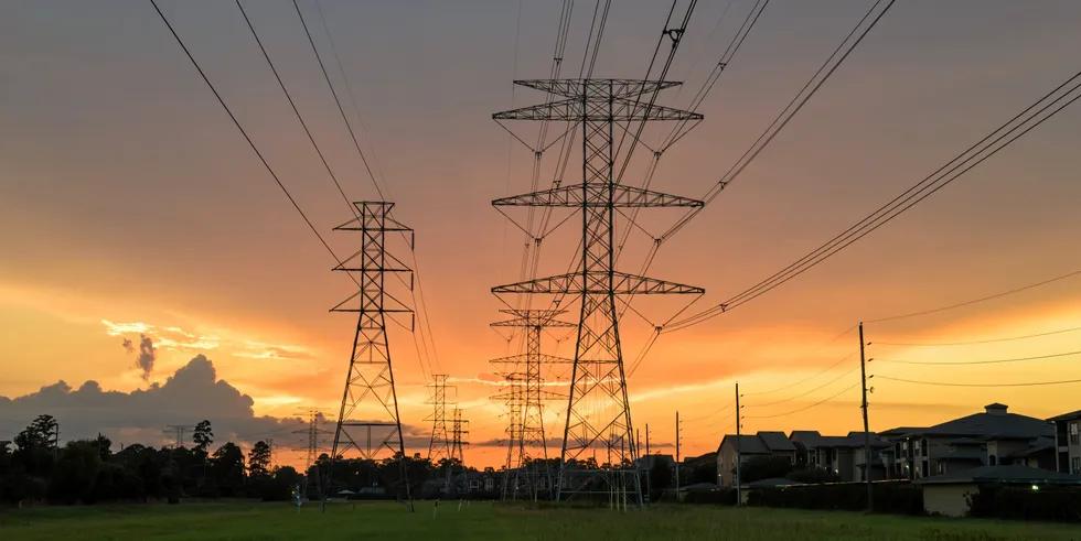 Group silhouette of transmission towers at sunset in Humble, Texas, US