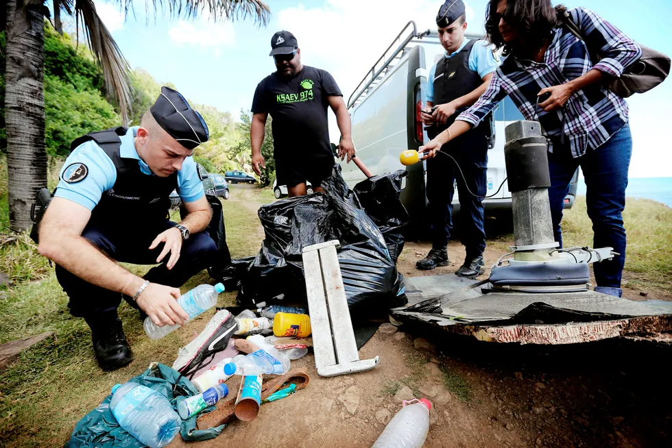 239 mennesker er antatt omkommet etter at et Malaysia Airlines-fly forsvant i 2014. Her inspekterer en fransk politimann vrakrester fra flyet som ble funnet på øst på øya Réunion i Indiahavet i 2015. Foto: RICHARD BOUHET/Afp/NTB scanpix