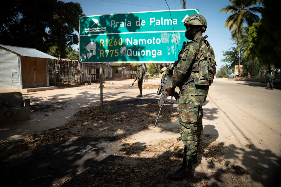 Armed presence: a Rwandan soldier walks in front of a burned truck near Palma, Cabo Delgado, Mozambique in September 2021, the closest town to TotalEnergies' Mozambique LNG construction site at Afungi