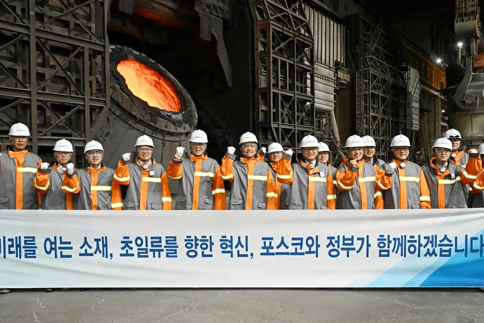 Finance minister (and deputy prime minister) Choi Sang-mok (centre) poses with Posco staff at a visit to the company's Pohang Steelworks last week. The banner reads: "Materials that open the future, innovations towards world-class status, Posco and the government will work together".