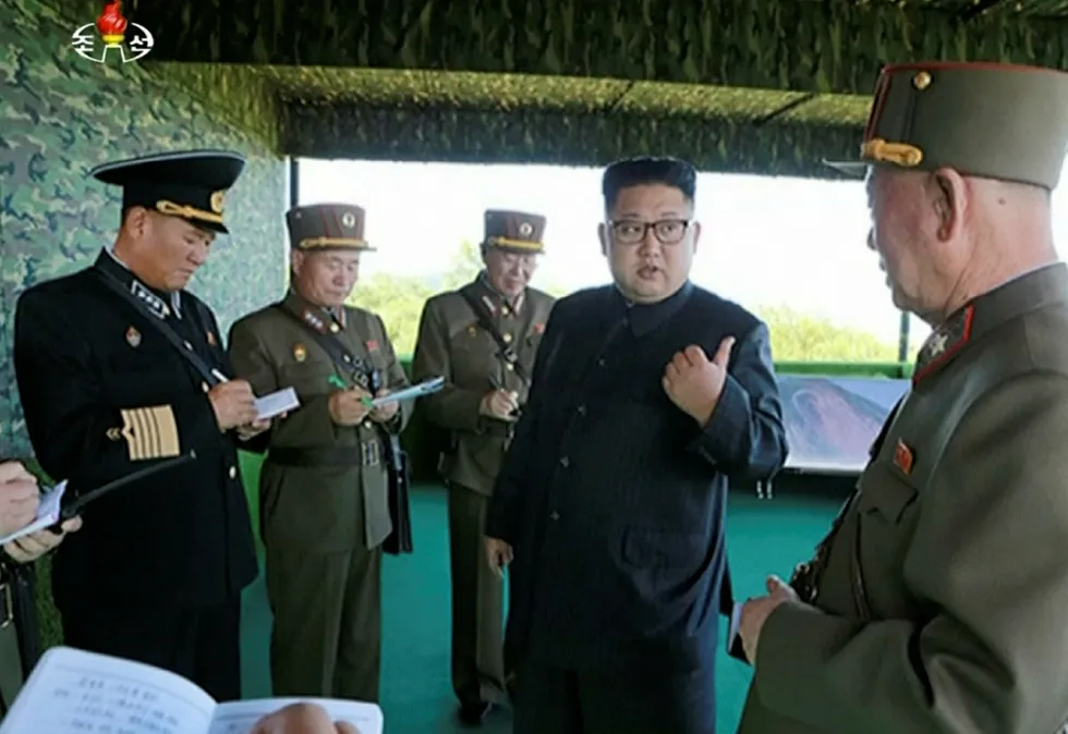 Nord-Koreas diktator, Kim Jong-un poserer sammen med militære. Han har bidratt til å øke spenningen betraktelig med en ny rakett som passerte over Japan. Foto: KRT via AP Video/NTB Scanpix