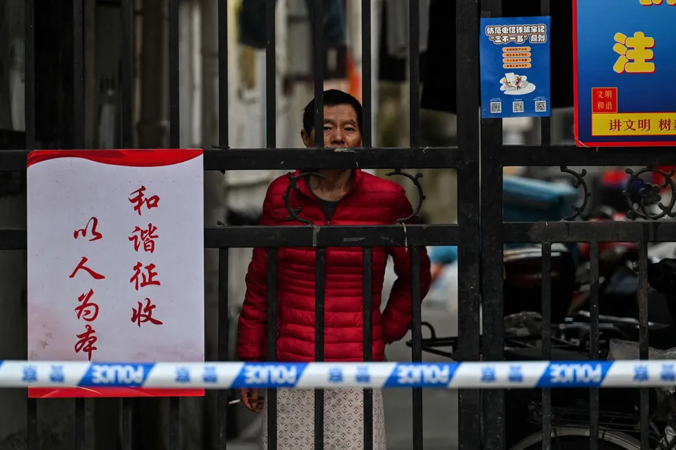 Increases: a resident looks at the street from their neighbourhood where barriers are being placed to close off streets around after the detection of new cases of Covid-19 in Shanghai