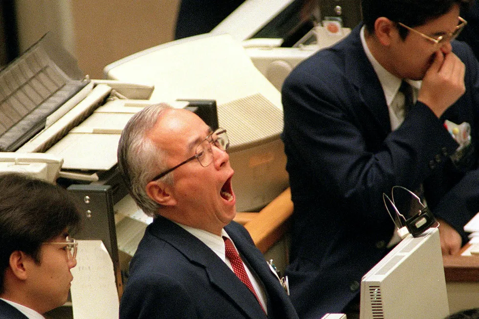 En aksjetrader som jobber på Tokyo-børsen gjesper høyt. Foto: YOSHIKAZU TSUNO/AFP