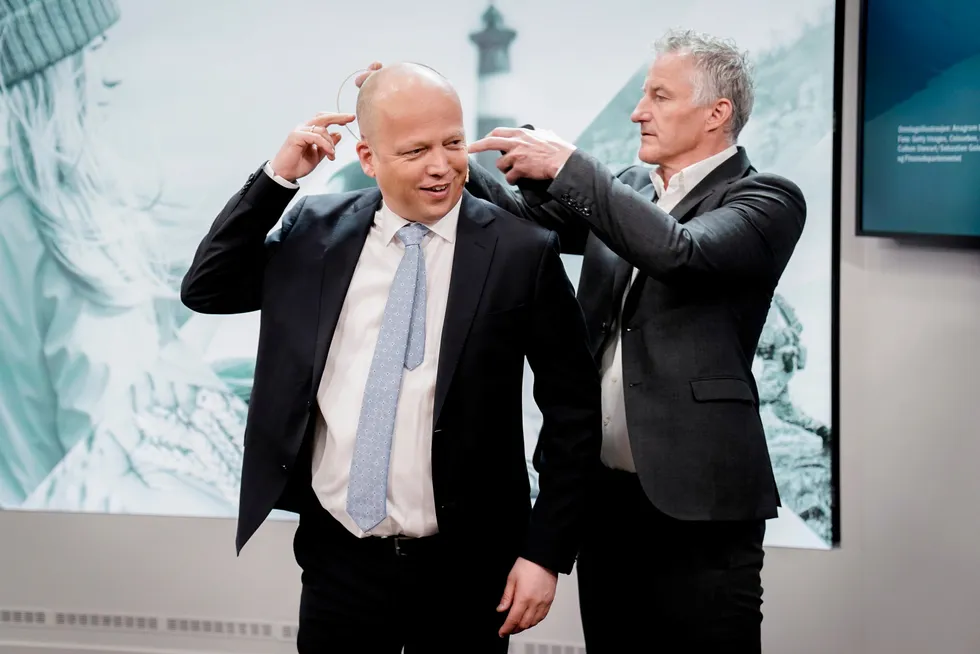 Finansminister Trygve Slagsvold Vedum får hjelp av kommunikasjonssjef Tor Borgersen med å feste mikrofonen før pressekonferansen om revidert nasjonalbudsjett torsdag formiddag.