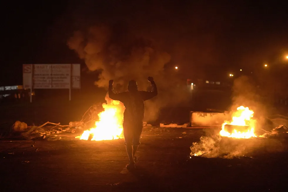 Protesting fuel prices: A demonstrator raises his hands in front of burning tires during a protest against fuel prices in Santiago, Veraguas province, Panama, last month.