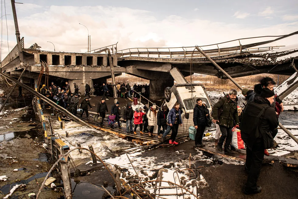 Sivile flykter under en bro ødelagt av russisk lutfangrep i byen Irpin i Ukraina.