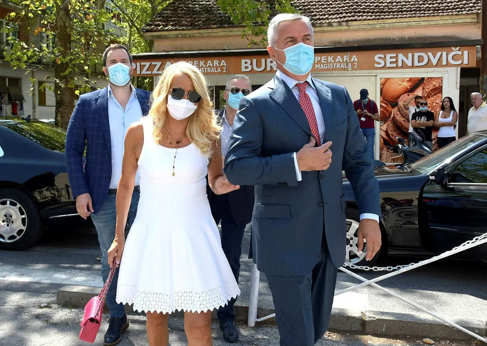 Montenegros president Milo Djukanovic og hans kone fotografert ved ankomst til valglokalet i Podgorica for å avlegge stemme ved søndagens valg. Presidentens parti ser ut til å bli det største, men veien videre er uviss.
