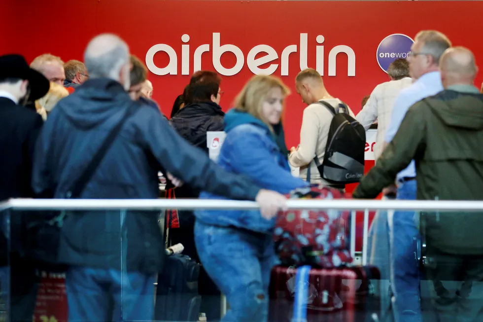 Reisende står i kø ved Air Berlins skranke på flyplassen i Düsseldorf etter at de møtte opp til en kansellert flyvning tirsdag. Foto: dpa via AP / NTB scanpix