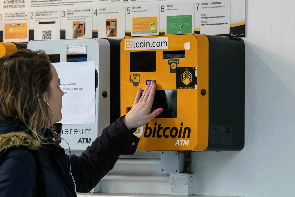 En kvinne studerer en «bitcoin-minibank» i Hong Kong. Den digitale valutaen setter stadig nye kursrekorder. Foto: Anthony Wallace/AFP/NTB Scanpix