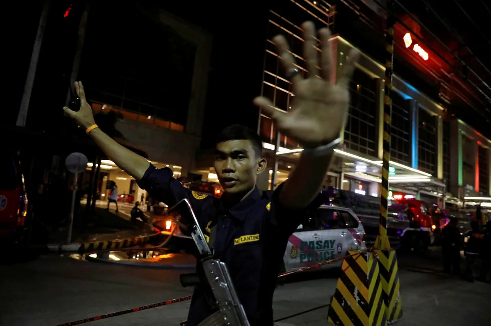 En sikkerhetsvakt stopper fotografer fra å gå inn i Resorts World Manila etter torsdagens angrep. Foto: Erik De Castro/Reuters/NTB scanpix