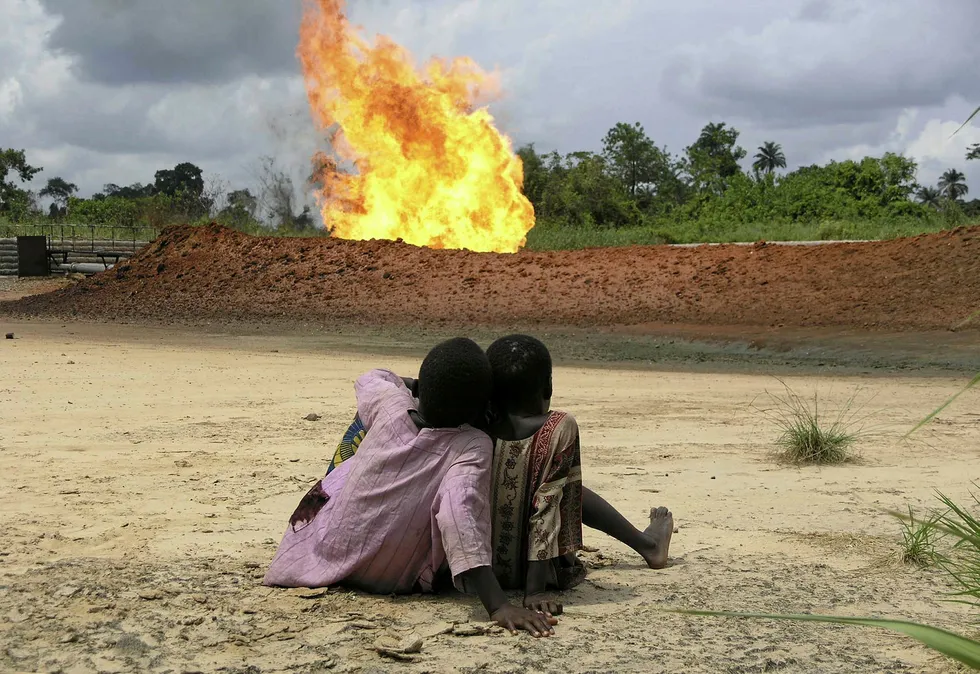 Children watch Shell gas flare at Rumuekpe, Nigeria