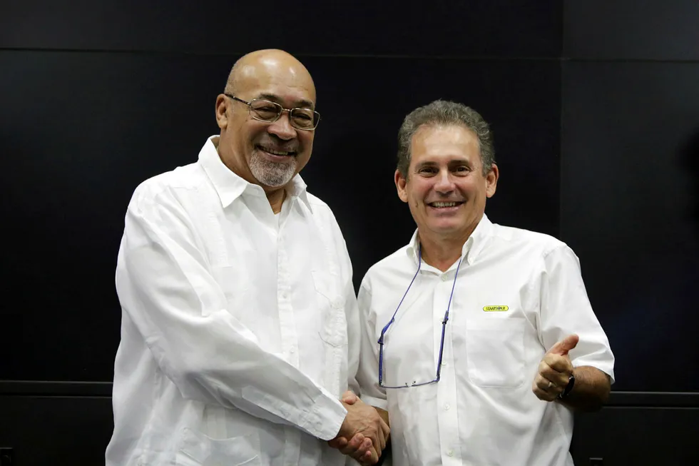 Golden handshake: Suriname's controversial President Desi Bouterse (left) congratulates Rudolf Elias, director of state-owned oil company Staatsolie, after learning that Apache had struck oil