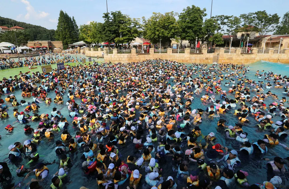 Folk bader fullt påkledt i Yongin i Sør-Korea. Det er varslet hetebølge flere byer i landet. Foto: Ahn Young-joon/AP/NTB Scanpix