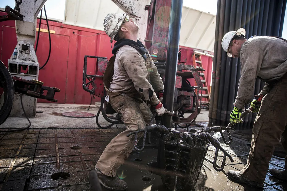 To riggarbeidere fra Sidewinder Drilling forsøker å koble fra hverandre et borerør på en borerigg utenfor Midland, Texas. USA er i ferd med å bli en stadig mer dominerende oljemakt. Foto: Jan Johannessen