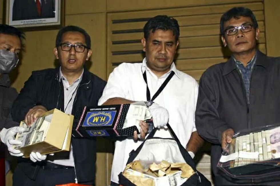 Busted: agents from Indonesia’s Corruption Eradication Commission (KPK) display bundles of US and Singapore dollars seized when Rudi Rubiandini was arrested