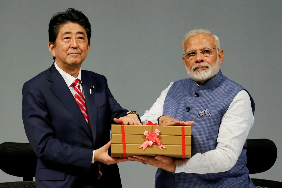 Japanese Prime Minister Shinzo Abe (L) and his Indian counterpart Narendra Modi hold a replica of a brick during the India-Japan Annual Summit, in Gandhinagar, India, September 14, 2017. REUTERS/Amit Dave