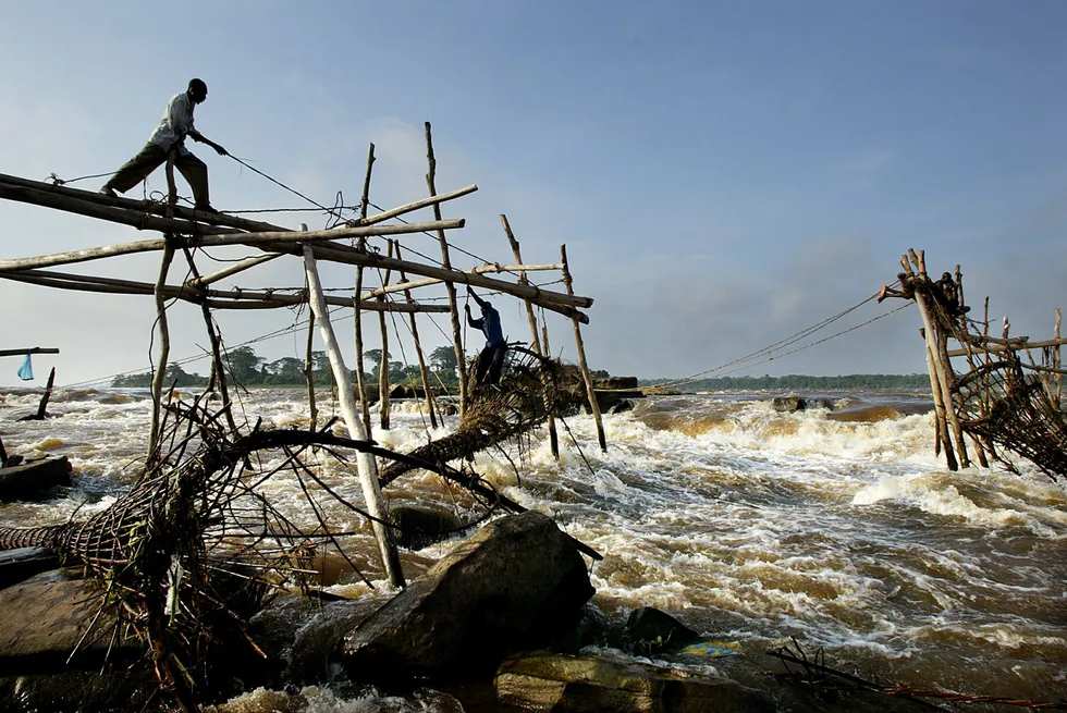 Powerful rapids: a man on top of a wooden structure made to hang fishing nets in Kisangani, Democratic Republic of Congo. The 2020 'turbidity current' event was caused by flooding in the upper reaches of the Congo River