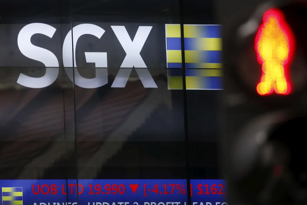 A traffic stop sign is pictured next to the Singapore Exchange stock board.