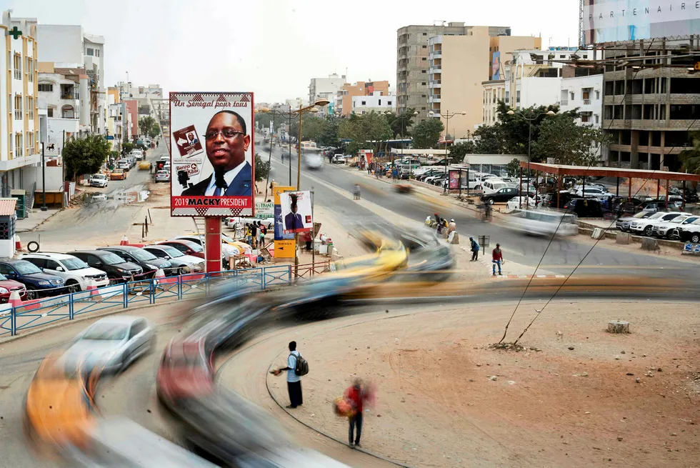 Centre point: vehicles move past a roundabout adorned with posters of Senegalese President Macky Sall in Dakar
