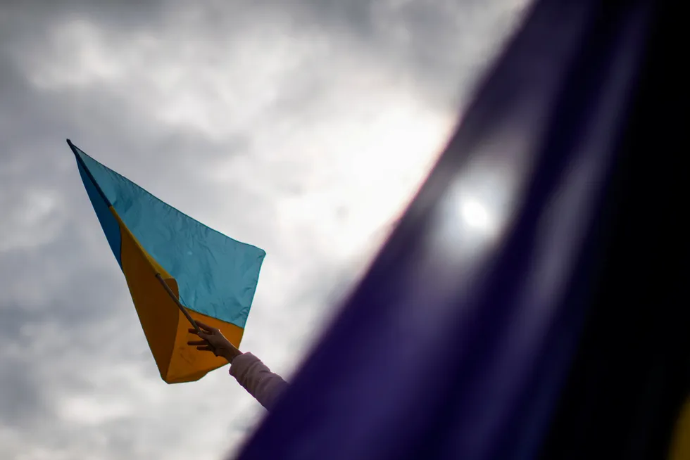 En kvinne vaier en ukrainsk flagg.