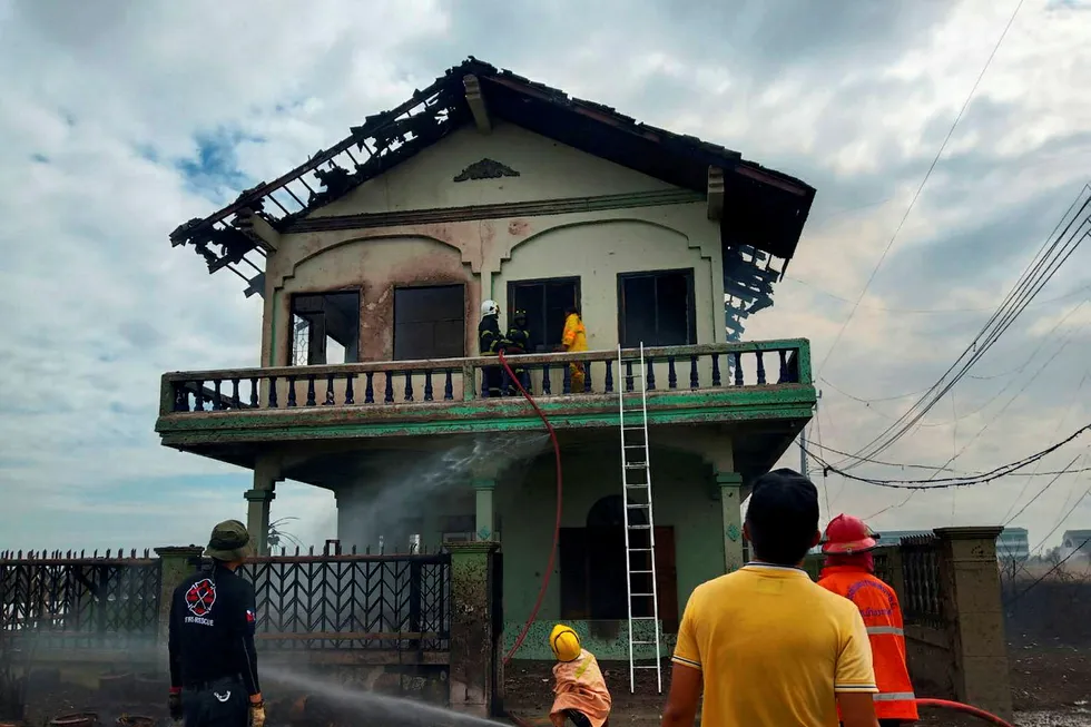 On site: Fire fighters extinguish a house near the site of explosions on a PTT gas transmission line in Samut Prakan province, Thailand
