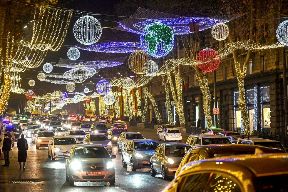 Georgia blocks round: vehicles drive down a street adorned with Christmas decorations in central Tbilisi in December