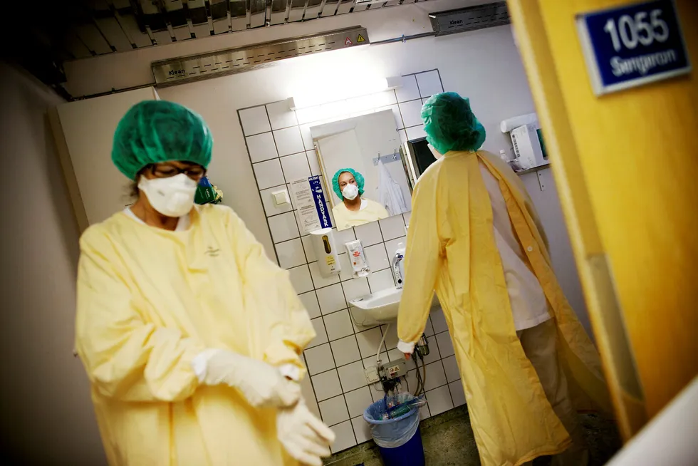 Lege Eyrund Kjetland og sykepleier Anette Schneider (ved speilet) på vei inn i et isolat på Ullevål sykehus. Foto: Linda Helen Næsfeldt