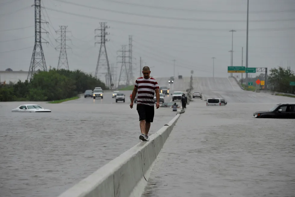 En mann balanserer mens han går langs motorveien Interstate 225 etter at orkanen Harvey rammet Texas. Det kan komme mer ekstremvær til USA om ikke lenge. Foto: Nick Oxford/Reuters/NTB Scanpix