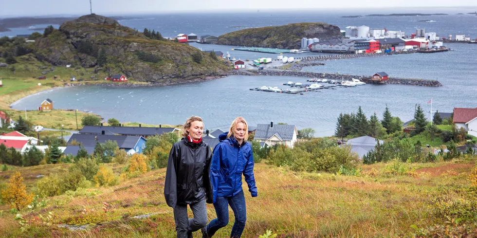 Fra venstre: søstrene Aino og Maria Olaisen er på tur oppover siden av Lovundfjellet. Bak ser vi Nova Sea sitt lakseslakteri.
