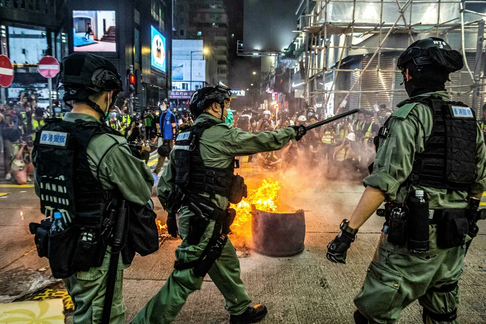 Tensions: police stand guard on a road to deter protesters from blocking roads in Hong Kong