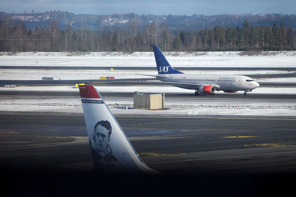 Avbildet er et SAS-fly og et Norwegian-fly på Oslo Lufthavn. Foto: Javad Parsa