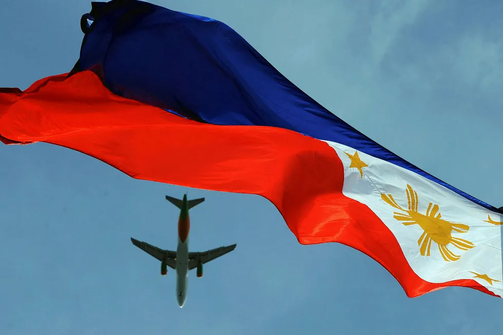 Flying the flag: an aircraft flies over a Philippine flag in Manila