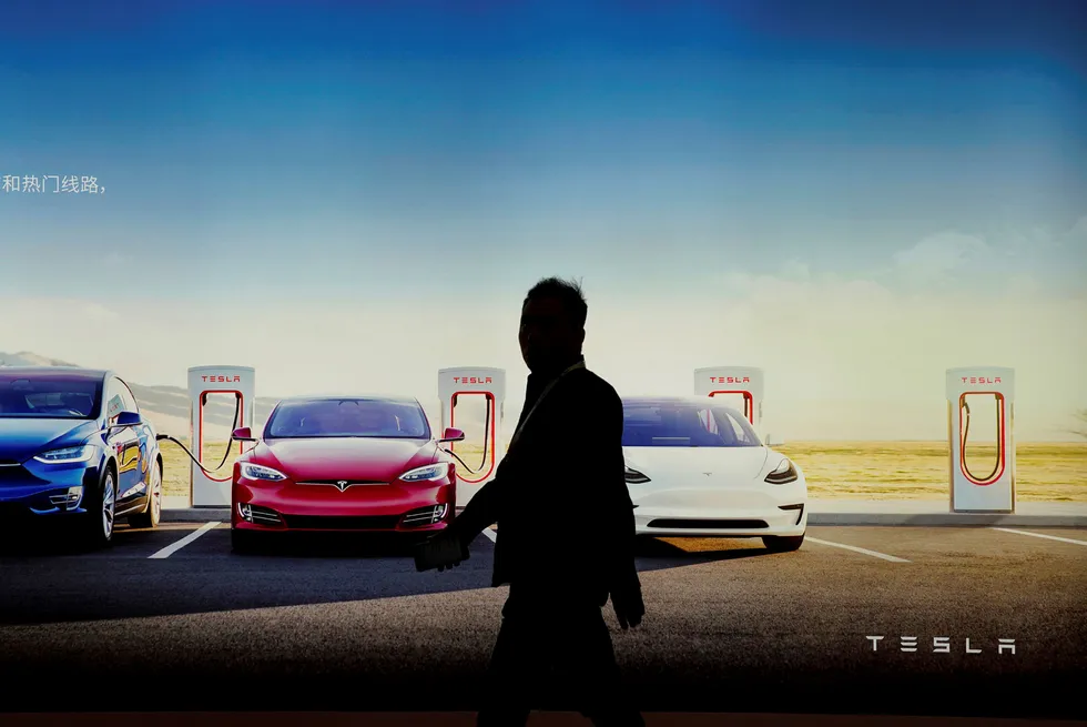 En person går forbi Teslas veggreklame under bilmessen i Shanghai, Kina i april 2019.