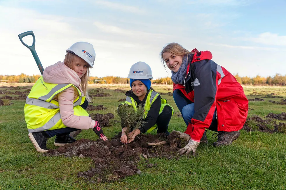 Field trip: Seaton Primary School pupils and North Star Group accountant Anita Campbell plant trees in the new woodland area being created next to the school as part of North Star’s sustainability programme