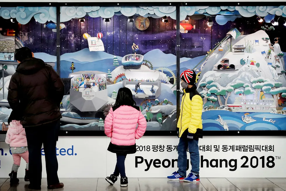 Noen barn ser på en temautstilling over OL-arenaene på jernbanestasjonen i Seoul. En nyåpnet høyhastighetslinje tar utenlandske besøkere fra den internasjonale flyplassen i Incheon til de olympiske arenaene på under to timer med tog. Foto: Lee Jin-man/AP/NTB Scanpix