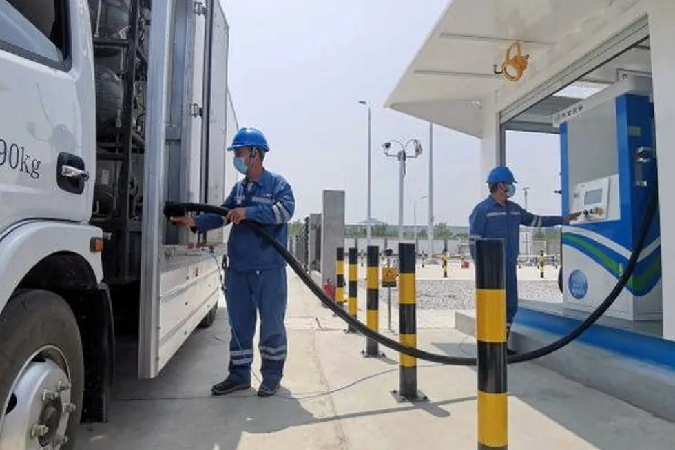 Hydrogen-powered: staff refilling buses with hydrogen at a hydrogen station in Yanqing, Beijing