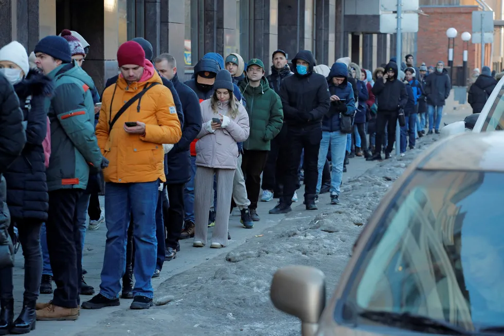 Russere står i kø utenfor en bank i St. Petersburg for å ta ut russiske rubler søndag 27. februar.