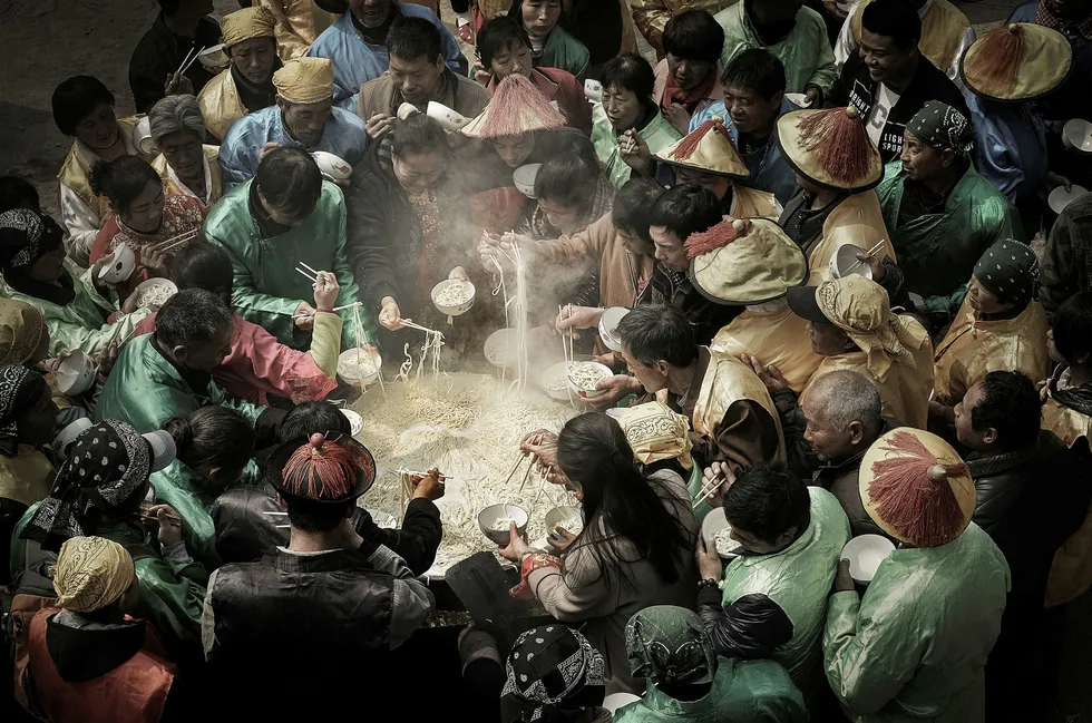 Kinesere, iført drakter fra Qing dynastiet, feirer guden Nuwa med et stort festmåltid bestående av nudler. Bildet er fotografert av den kinesiske fotografen Jianhui Liao og er kåret til årets matfoto av konkurransen The Foodphotographer of the year.