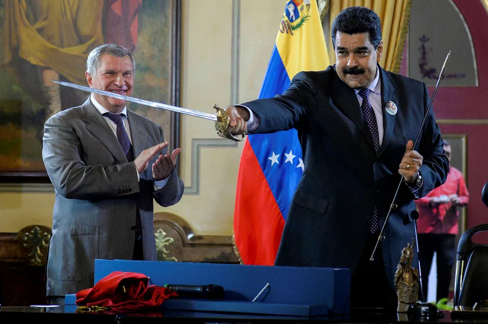 No passaran: Venezuelan President Nicolas Maduro (right) holds a sword, given as gift by Rosneft executive board chairman Igor Sechin, during the signing of oil and gas agreements in Caracas