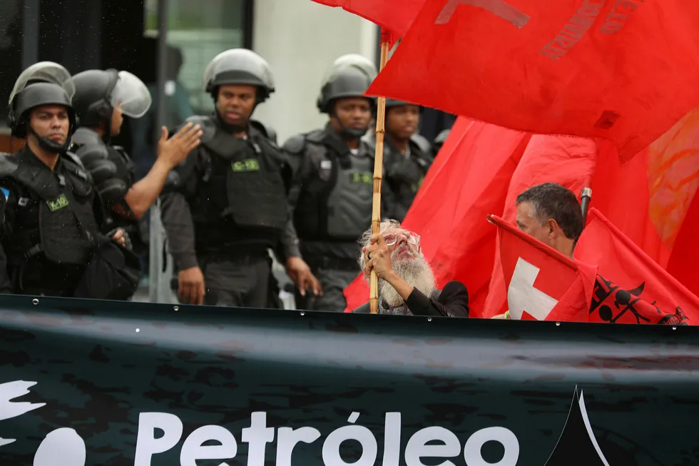 En mann holder et flagg under demonstrasjoner i Rio de Janeiro på lørdag. Den siste uken har lastebilsjåfører i Brasil gått ut i streik på grunn av økte drivstoffpriser. Foto: Pilar Olivares, Reuters/NTB Scanpix
