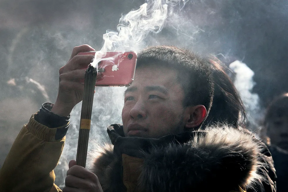 Børsverdier på 400 milliarder dollar har forsvunnet for Apple siden oktober. Her tar en kinesisk mann bilder med en Iphone under nyttårsfeiringen.